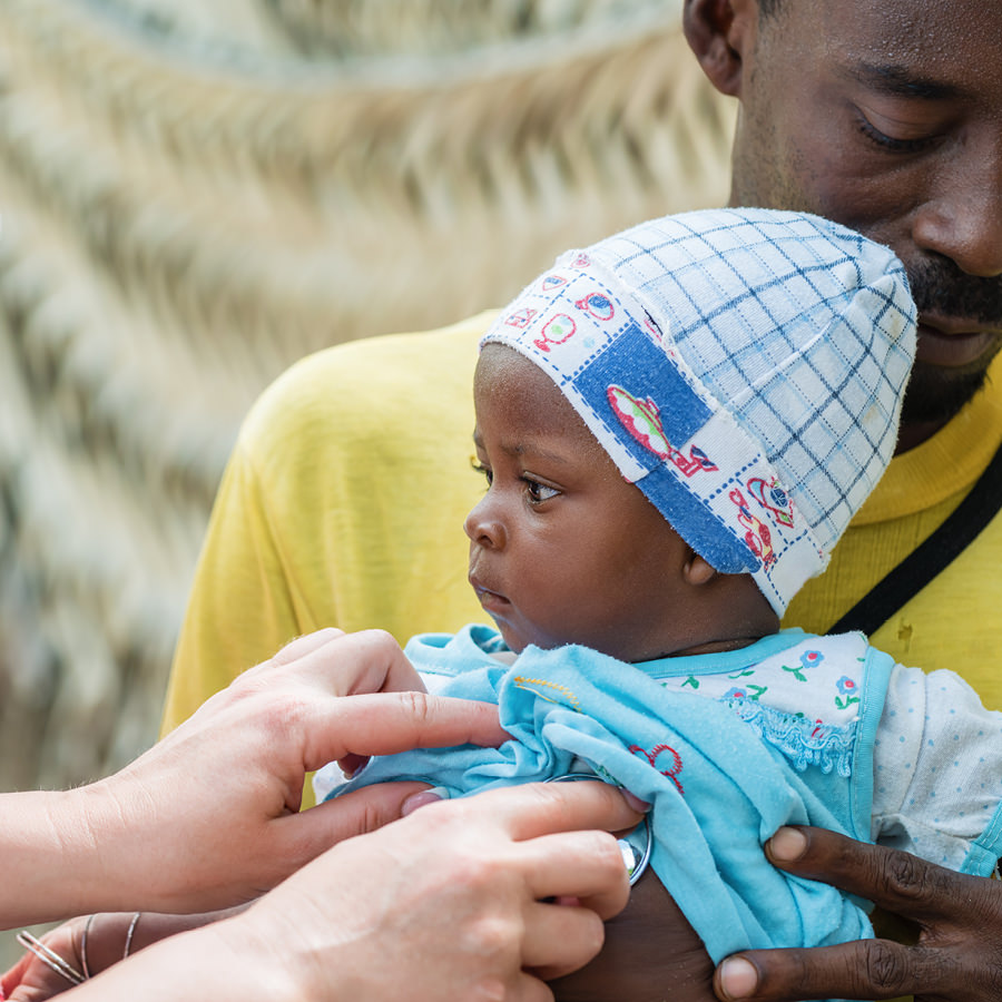 Ärztin untersucht Baby in Afrika
