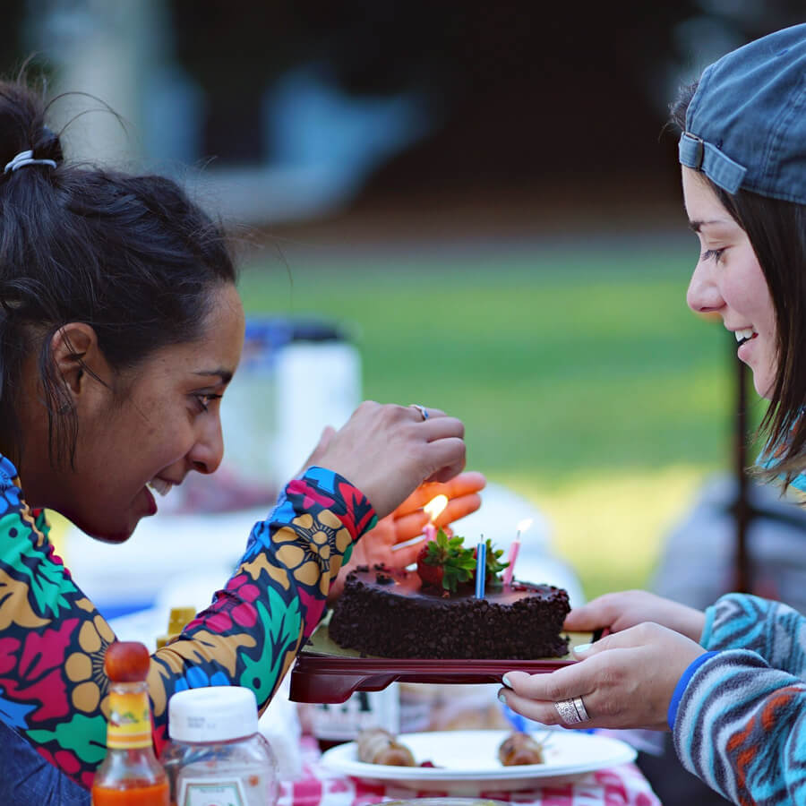 Zwei Mädchen dunkel- und hellhäutig mit Kuchen